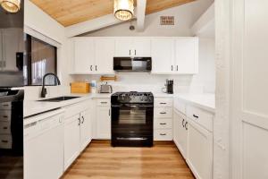 a kitchen with white cabinets and black appliances at 2354-Chairlift Lodge condo in Big Bear Lake