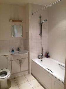 1 Bedroom Flat near Excel, O2, Canary Wharf - London في لندن: حمام مع مرحاض وحوض استحمام ومغسلة