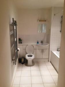 1 Bedroom Flat near Excel, O2, Canary Wharf - London في لندن: حمام ابيض مع مرحاض ومغسلة