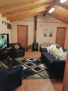 uma sala de estar com dois sofás e uma televisão em Piso acogedor y familiar en el campo em Villarrica