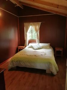 um quarto com uma cama grande e uma janela em Piso acogedor y familiar en el campo em Villarrica