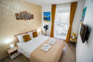 een slaapkamer met een groot bed en een televisie bij Modern & Comfortable Apartament Cismigiu Park - POP3 in Boekarest