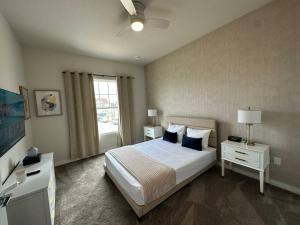 Un dormitorio con una cama con almohadas azules y una ventana. en Beautiful 5 bed home Resort 5 minutes from Disney, en Orlando 15 fotos más