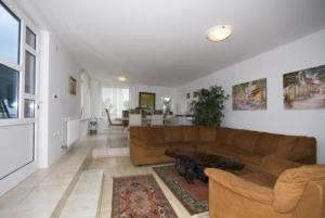 a living room with a brown couch and a table at Villa Palme 1 in Opatija