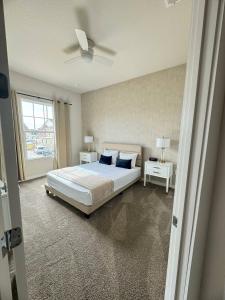 Un dormitorio con una cama y un ventilador de techo. en Beautiful 5 bed home Resort 5 minutes from Disney, en Orlando