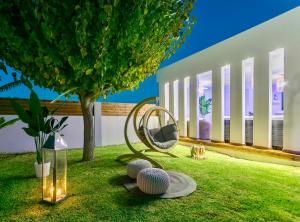 einen Garten mit einem Stuhl und Bällen auf dem Rasen in der Unterkunft Muthee Luxurious Private Villa in Laganas