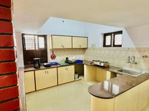 een keuken met een wastafel en een aanrecht bij Malgudi House - Viceroy in Mysore
