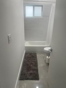 een badkamer met een bad, een toilet en een raam bij The Lake House in Fort Lauderdale