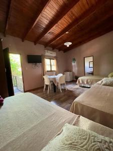 a bedroom with two beds and a table with chairs at LA SELVA MONOAMBIENTES in Puerto Iguazú