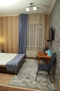 sypialnia z łóżkiem, stołem i krzesłem w obiekcie VIP Mini Hotel w mieście Semej