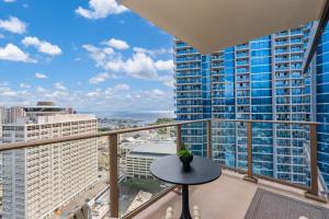a balcony with a table and a view of the city at Sky Ala Moana 3001 condo in Honolulu
