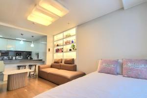 sypialnia z łóżkiem i kanapą oraz kuchnia w obiekcie Lavender House-IRUA w Pusanie