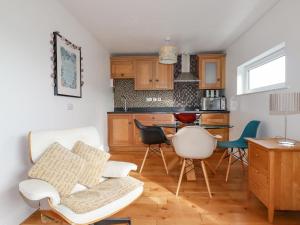 a living room with a table and chairs in a kitchen at Lapwing in Perranporth