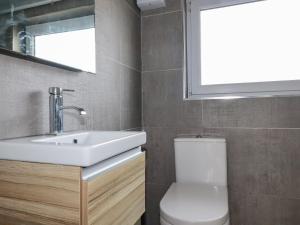 a bathroom with a sink and a toilet and a window at Lapwing in Perranporth +6 photos