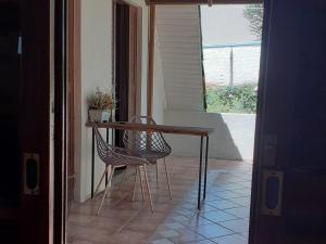 una mesa y una silla junto a una mesa y una ventana en Chalé ensolarado, bairro Frei Rogerio en Lages