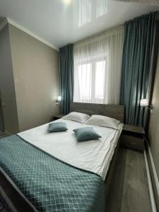 a bedroom with a large bed with two pillows on it at VIP Mini Hotel in Semey