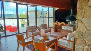 a living room with a table and chairs and a large window at Wanderlust Experience Hotel Best Western in Campos do Jordão