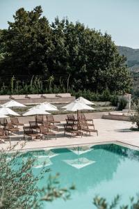 a swimming pool with lounge chairs and umbrellas at Lamego Hotel & Life in Lamego