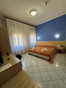 ein Schlafzimmer mit einem Bett und einer blauen Wand in der Unterkunft Albergo La Posta Arezzo in Badia Al Pino