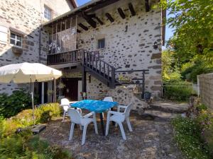 un patio con mesa, sillas y sombrilla en Les Cavaleries, en Nonards