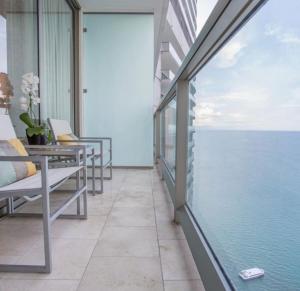 einen Balkon mit Stühlen und Meerblick in der Unterkunft JW MARRIOT in Panama-Stadt