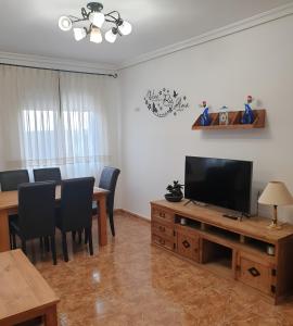 een woonkamer met een eettafel en een televisie bij La tranquila Manchuela in Alborea