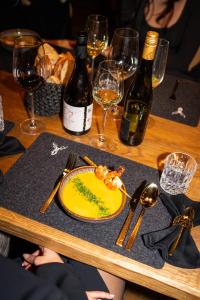 una mesa con un plato de comida y botellas de vino en Kellnergut Luxus-Chalet "FRIEDA", en Mühlbach am Hochkönig
