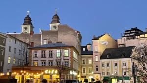 un gruppo di edifici su una strada di città di notte di LINZ CITY CENTER - Historisches Apartment & Refugium a Linz