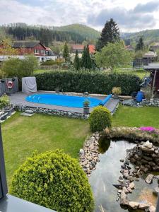 a backyard with a pond and a swimming pool at Ferienwohnung-Auszeit in Bad Harzburg