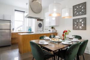 une cuisine avec une table en bois et des chaises vertes dans l'établissement MTLVacationRentals -The Chic Laurier, à Montréal