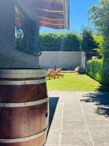 a wooden barrel sitting next to a yard with benches at Las Viñas Hostel Boutique in San Carlos de Bariloche