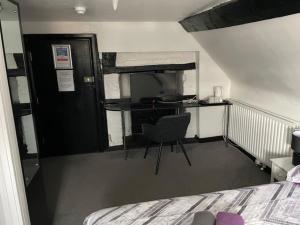 a bedroom with a desk and a chair next to a bed at The White Hart Inn in Twickenham