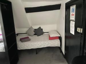 ein kleines Schlafzimmer mit einem kleinen Bett in einem Zimmer in der Unterkunft The White Hart Inn in Twickenham