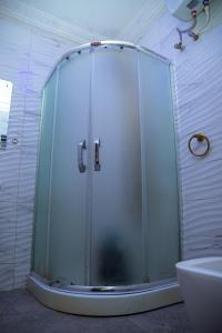 y baño con ducha y puerta de cristal. en Haffy Executive Hotels and Suite en Uyo