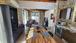 Casa con cocina y sala de estar con mesa de madera. en Olive Garden's Paradise Villa, en Skarinou