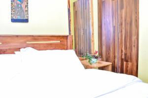 a bedroom with a bed with a wooden headboard at Four seventy in Meru