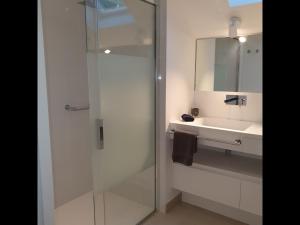 uma casa de banho com uma cabina de duche em vidro e um lavatório. em Le Rocher Vert - Duplex climatisé pour 4 em Saint Barthelemy