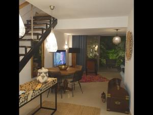 uma sala de estar com uma escada em espiral e uma sala de jantar em Le Rocher Vert - Duplex climatisé pour 4 em Saint Barthelemy