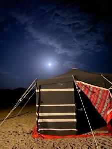 una tienda sentada en la playa por la noche en Sahara INN Smart Resort & Camping en Dubái