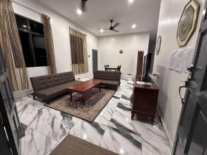 Bangi Utara Villa في كاجانغ: غرفة معيشة مع أريكة وطاولة