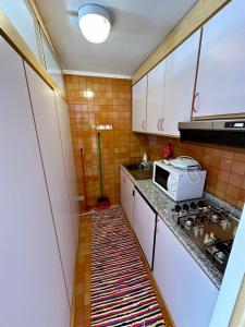 a small kitchen with a sink and a microwave at Bilocale Rio Falzè - Serafini in Madonna di Campiglio