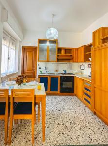 een keuken met houten kasten en een tafel en stoelen bij La casita A&B in La Spezia