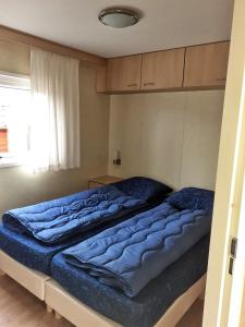 een slaapkamer met 2 bedden met blauwe lakens bij Beach Resort Kamperland - BRK 414 in Kamperland
