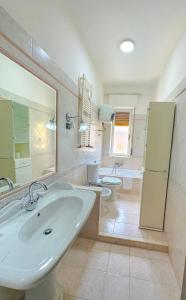 een badkamer met een wastafel en 2 toiletten bij La casita A&B in La Spezia