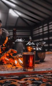 ドバイにあるSahara INN Smart Resort & Campingの暖炉の横のテーブルに座ってお茶