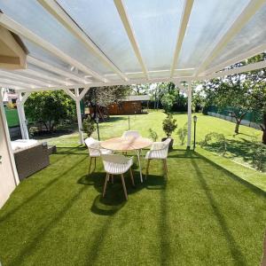 a patio with a table and chairs under a white pergola at ABG House Pest in Budapest