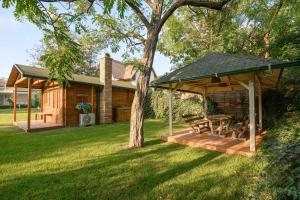 a gazebo with a bench and a tree in a yard at ABG House Pest in Budapest