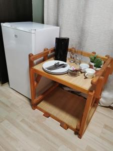 a small wooden table with a white refrigerator at Karoozin Village in Oudtshoorn