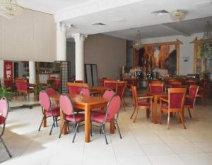 ヴィエリチカにあるHotel Salisのダイニングルーム(木製テーブル、赤い椅子付)