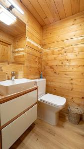 a wooden bathroom with a toilet and a sink at ABG House Pest in Budapest